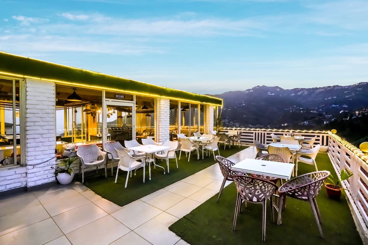 Rooftop tables at dusk with the valley beyond